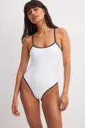 NA-KD Swimwear Badedrakt med kontrastbinding og detaljer - White